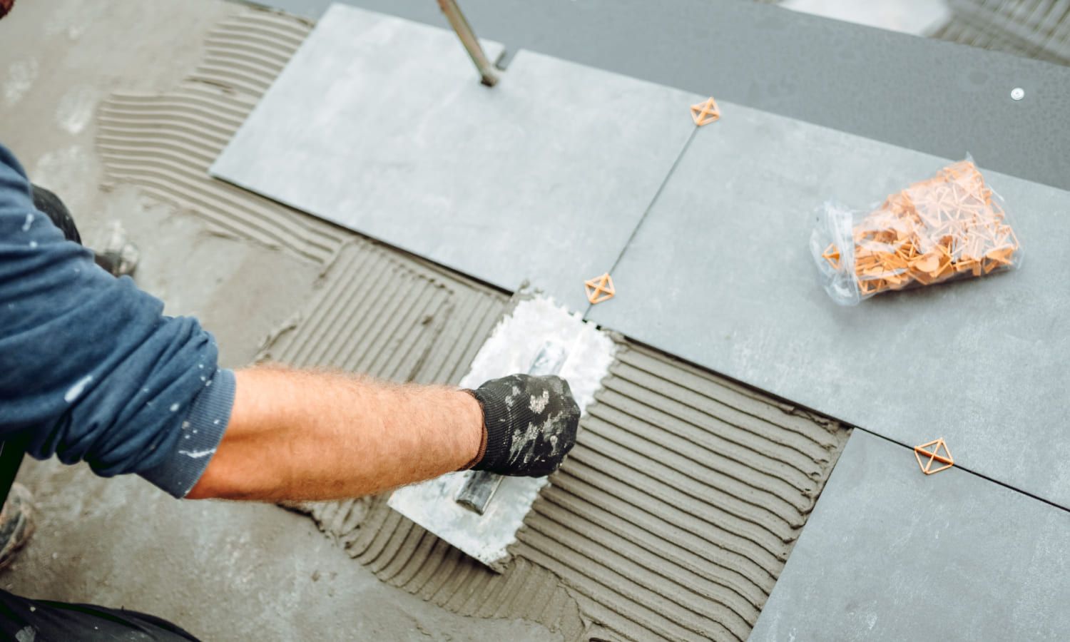 Eine Person verlegt Fliesen